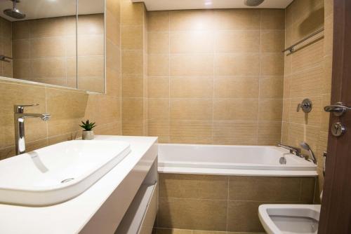 a bathroom with a tub and a sink and a bath tub at Vinhomes Metropolis luxury Hotel & Residence in Hanoi
