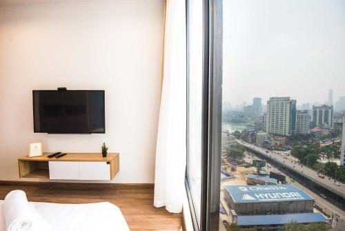 a living room with a tv and a large window at Vinhomes Metropolis luxury Hotel & Residence in Hanoi
