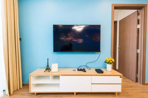 a room with a blue wall with a tv on the wall at Vinhomes Metropolis luxury Hotel & Residence in Hanoi