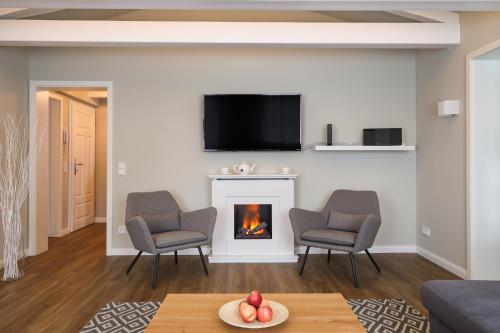 a living room with a fireplace and a tv at Villa Oestereich in Binz