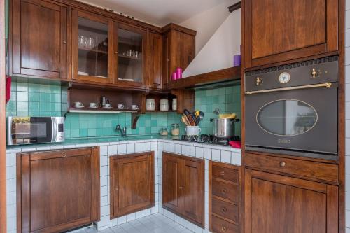 - une cuisine avec des placards en bois et une cuisinière dans l'établissement Portinari Apartment, à Florence