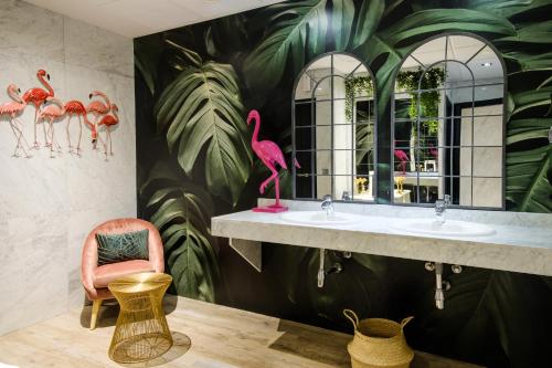 uma casa de banho com 2 lavatórios e um mural de flamingo rosa em Clement Barajas em Madri