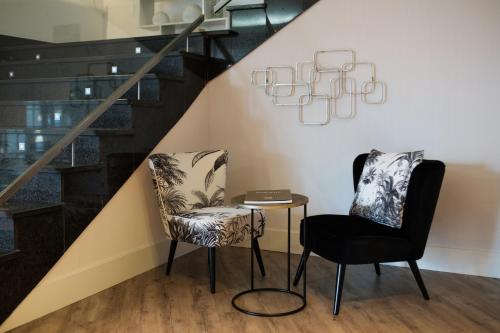 two chairs and a table under a staircase at Clement Barajas in Madrid