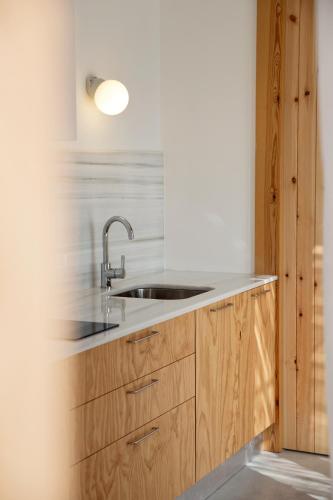 a kitchen with a sink and wooden cabinets at Sa Nau Agroturismo - Adults Only over 16 in Portocolom
