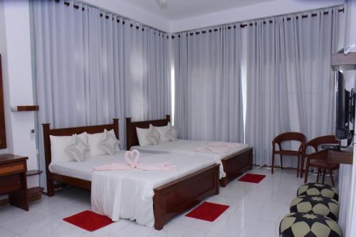 a bedroom with two beds with pink bows on them at New Ocean Hill Hotel in Hikkaduwa