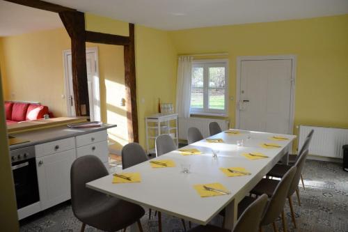 a dining room with a white table and chairs at Deichkind - Reetdachhaus direkt am Elbdeich in Mödlich