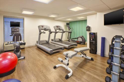 a fitness room with cardio equipment and a flat screen tv at Holiday Inn Express & Suites Chicago-Midway Airport, an IHG Hotel in Bedford Park