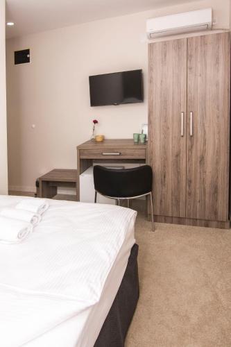 a bedroom with a bed and a desk with a television at Beo Green View in Belgrade