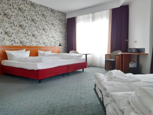 a hotel room with two beds and a window at Good Morning + Leipzig in Leipzig