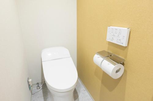 a bathroom with a toilet and a roll of toilet paper at M's Hotel Sanjo Omiya in Kyoto