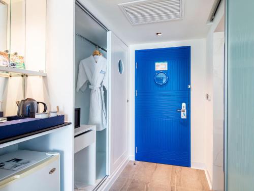 a blue door in a white kitchen with a dresser at A-One New Wing Hotel in Pattaya