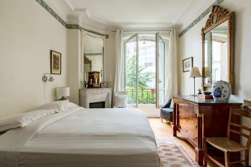 a bedroom with a bed and a desk and a mirror at Veeve - Enchanting Murals by Trocadero Gardens in Paris