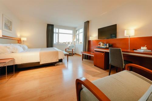 Abba Euskalduna Hotel في بلباو: غرفة في الفندق مع سرير ومكتب