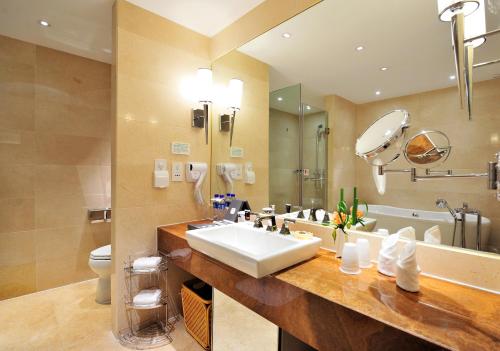 a bathroom with a sink and a toilet and a tub at Changchun Huatian Hotel in Changchun