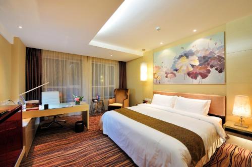 a hotel room with a large bed and a desk at Changchun Huatian Hotel in Changchun