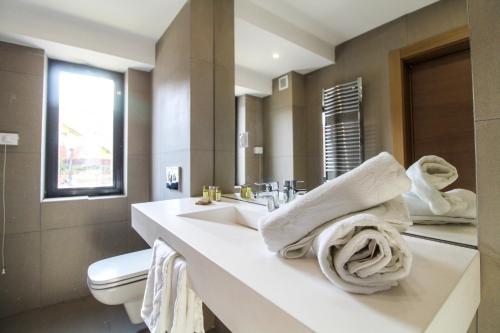 łazienka z umywalką, toaletą i ręcznikami w obiekcie Hotel Avenue - Avenue Hotels w mieście Buzău