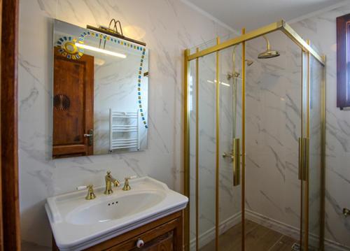 uma casa de banho com um lavatório e um chuveiro com um espelho. em Aydos Konakları em Muğla