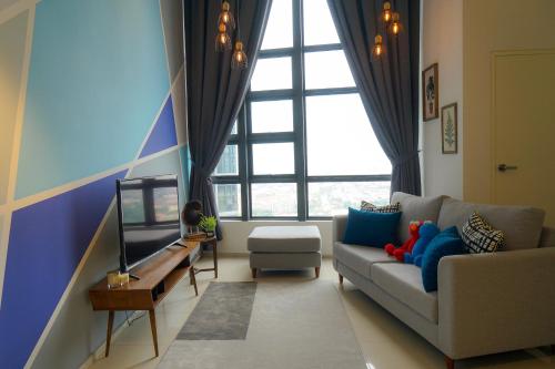 a living room with a couch and a large window at Cozy Modern Loft by De Lux @ EkoCheras, KL in Kuala Lumpur