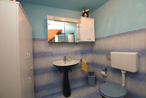 a bathroom with a sink and a toilet and a mirror at Apartment Dragica 1492 in Vodnjan