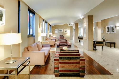 a living room with couches and a long line of tables at Abba Euskalduna Hotel in Bilbao