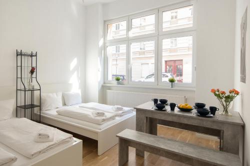 ein weißes Wohnzimmer mit einem Bett und einem Fenster in der Unterkunft Newton-Appartement mit 3 Schlafzimmern in Berlin