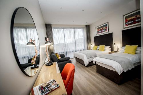 a hotel room with two beds and a mirror at The James Suites in Derry Londonderry
