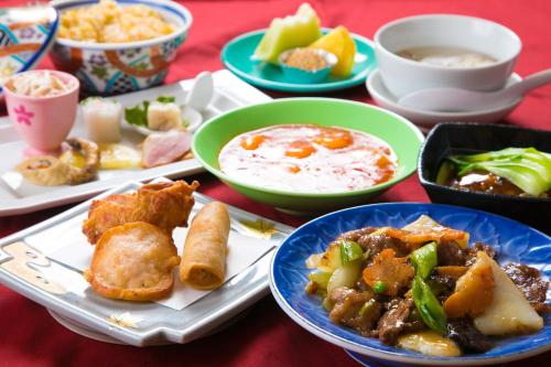 a table with plates of food and bowls of food at Hotel Satsukien in Kanoya