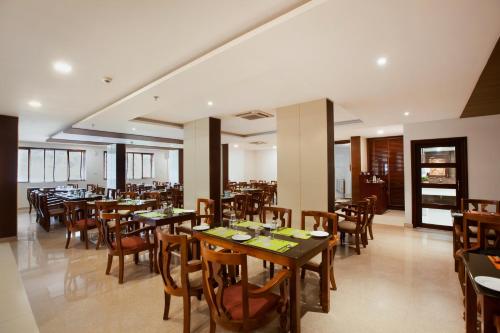 a dining room with wooden tables and chairs at Sterling Thekkady in Thekkady