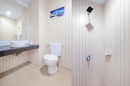 a bathroom with a toilet and a sink and a shower at SUPER OYO Capital O 472 Hotel Asyra in Makassar