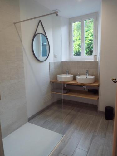 a bathroom with two sinks and a mirror at La Maison d'Aure in Arreau