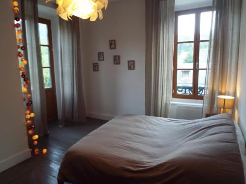 a bedroom with a bed and a chandelier at La Maison d'Aure in Arreau
