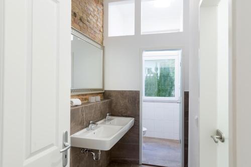 ein Badezimmer mit Waschbecken und Fenster in der Unterkunft Newton-Appartement mit 3 Schlafzimmern in Berlin