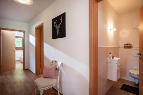 łazienka z toaletą i krzesłem w obiekcie Appartement Annabella w mieście Söll