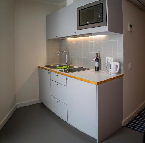 a small kitchen with a sink and a microwave at Kassari Puhkekeskus in Käina
