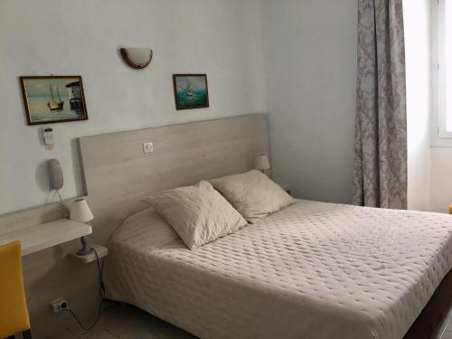 a small bedroom with a bed and a window at Hotel de la Plage Santa Vittoria in Algajola