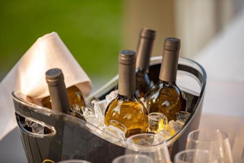 a basket of wine bottles and glasses on a table at Relais Bellaria Hotel & Congressi in Bologna