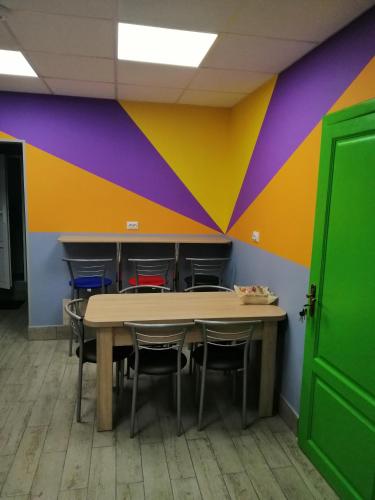 a table and chairs in a room with a colorful wall at Hostel Meridian in Kyiv