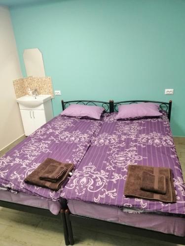 a purple bed with two towels on top of it at Hostel Meridian in Kyiv