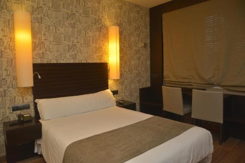 Brionにあるホテル ガストロノミコ カーサ ロザリアのベッドルーム1室(ベッド1台、テーブル2台、椅子付)