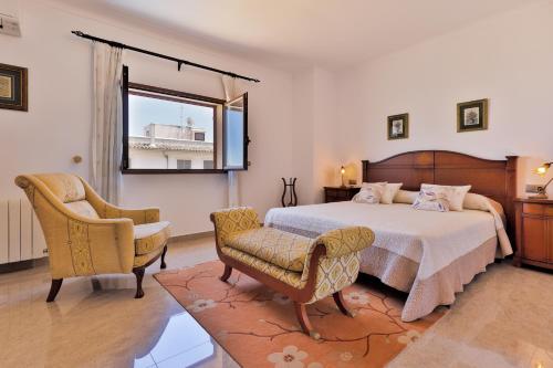 1 dormitorio con 1 cama, 1 silla y 1 ventana en Villa Vidal, en Portopetro