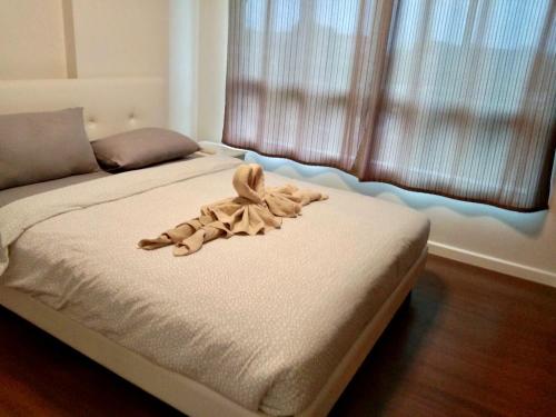 a stuffed animal laying on a bed in a bedroom at BanKunKoey A501 2 Bed Condo Mountain view Near Blue Ports 300m from the Beach in Hua Hin