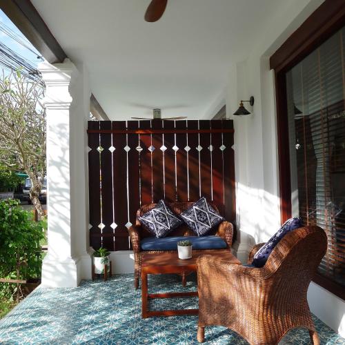 a porch with a couch and a chair at Residence Bassac in Champasak