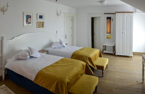a hotel room with two beds with yellow sheets at Hotel Coquette in Măneciu