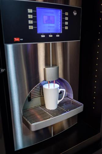a coffee cup sitting on a rack in a microwave at Campanile Toulouse Purpan in Toulouse