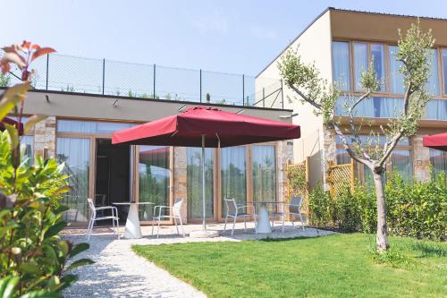 a patio with a red umbrella in front of a building at Antico Podere San Francesco in Vada
