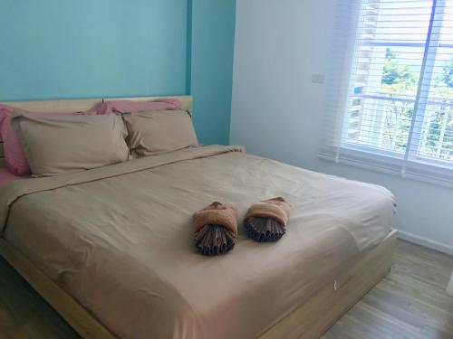 twee handschoenen op een bed bij Summer Huahin 323,Near Beach&Cicada,Beautiful swimming pool in Hua Hin