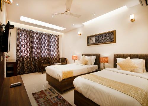 a hotel room with two beds and a window at Imperial Apartment Fortis in Gurgaon