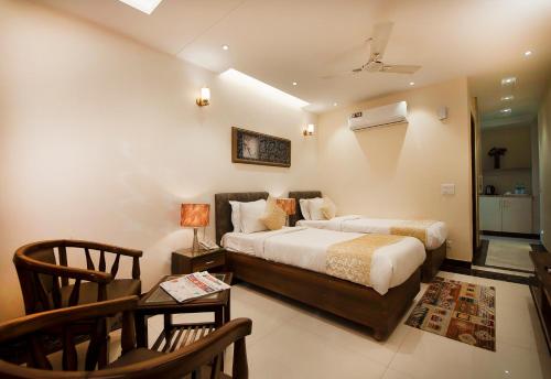 een slaapkamer met een bed en een tafel en stoelen bij Imperial Apartment Fortis in Gurgaon