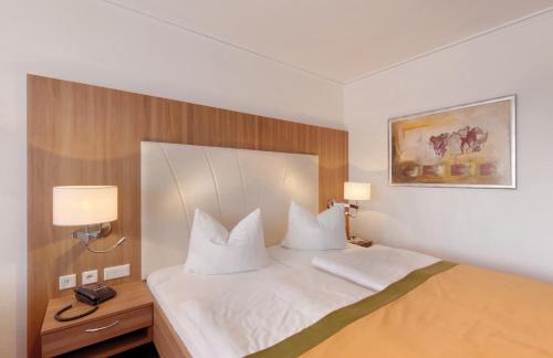 a hotel room with a large bed with two pillows at Johannesbad Thermalhotel Ludwig Thoma in Bad Füssing