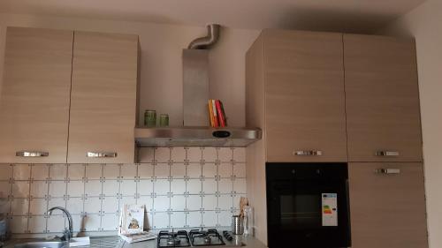 a kitchen with a sink and a stove and cabinets at Casa Clelia in Monsummano